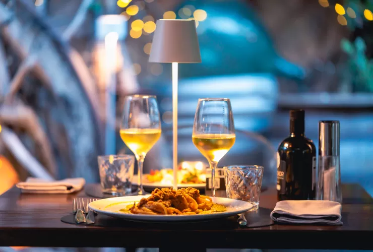 tavolo apparecchiato con pietanze e calici di vino